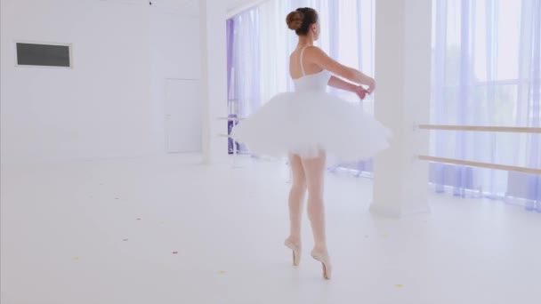 Ballerina in white tutu and pointes is spinning in dance in ballet class. — Stock Video