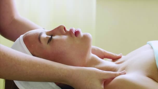 Giovane donna gode di massaggio facciale nel salone di bellezza spa sul trattamento benessere . — Video Stock