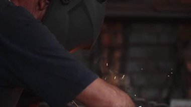 Koruyucu maskeli kaynakçı, metalin yavaş çekimde elektrik ark ı sabunu sağlar.