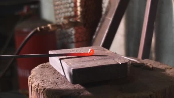 Blacksmith works hit hammer hot metal bar to bend it on anvil in forge workshop. — Stock Video