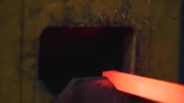 Sıcak kırmızı kenarlı metal çubuk forge basmak için sanat dövme makinesi koymak.