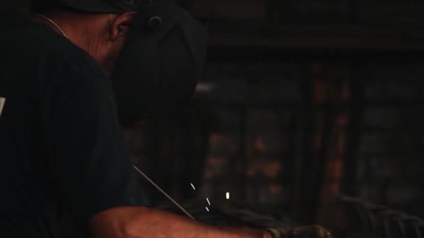 Soldador em máscara protetora faz soldagem a arco elétrico de metal . — Vídeo de Stock