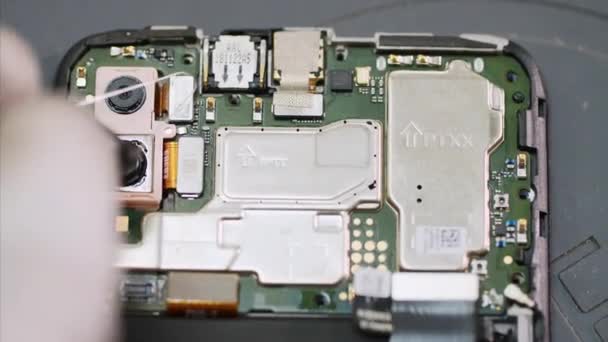 Reparador profesional elimina la cámara del chipset de teléfonos inteligentes en el taller . — Vídeos de Stock