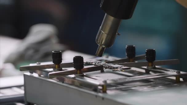 Heating chipset using soldering blow dryer for repair breakdowns in workshop. — Stock Video