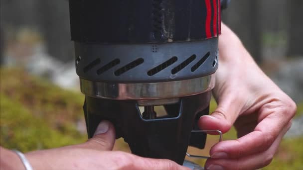 Ženský ruce obracejí plynový hořák v kempu na přírodu k teplé vodě na čaj. — Stock video