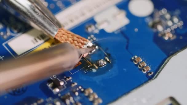 El reparador está soldando la limpieza del microchip y quitando los residuos después de él . — Vídeo de stock