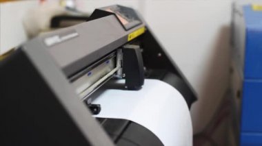 Baskı ofisinde kendinden yapışkanlı film kesen bilgisayarlı plotter makinesi.