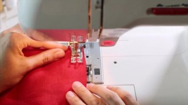Dikiş makinesinde kırmızı giysiler diken kadın terzi nin elleri.