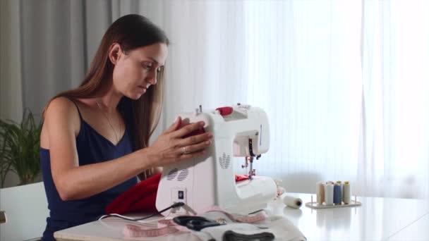 Самозанятая молодая женщина портной работает и шитье ткани на швейной машинке . — стоковое видео