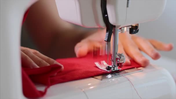 Χέρια της γυναίκας ράφτη ράψιμο κόκκινα ρούχα στη ραπτομηχανή με ευθεία ραφή. — Αρχείο Βίντεο