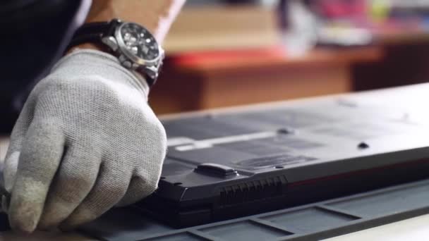 Reparateur verzamelt laptop na reparatie schroeven bedekken aan het lichaam in de werkplaats. — Stockvideo