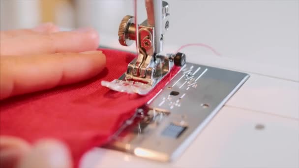 Hands of woman tailor sewing red clothing on sewing machine with straight seam. — Stock Video