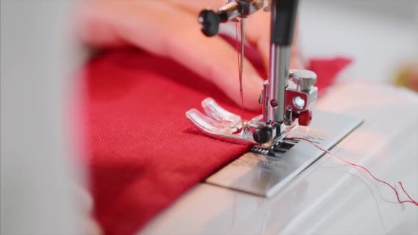 Hands of woman tailor sewing red clothing on sewing machine with straight seam. — Stock Video