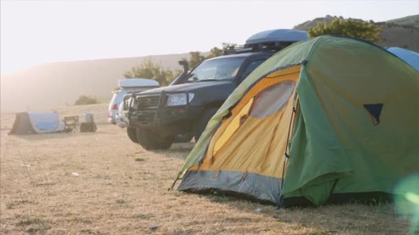 Jeune femme se réveille et sort de la tente touristique et s'étend — Video