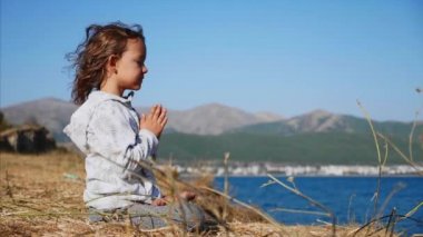 Sevimli küçük çocuk kız nilüfer tek başına meditasyon göl kıyısında poz