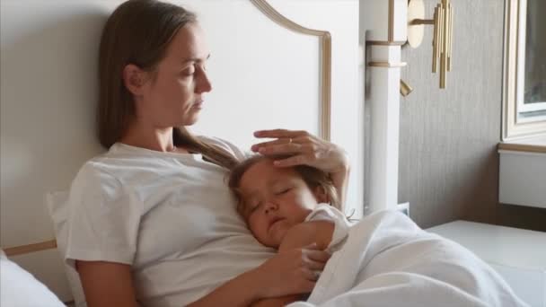 Matka ležela na posteli se svým spící dítětem doma. — Stock video