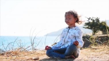 Sevimli küçük çocuk kız nilüfer tek başına meditasyon göl kıyısında poz