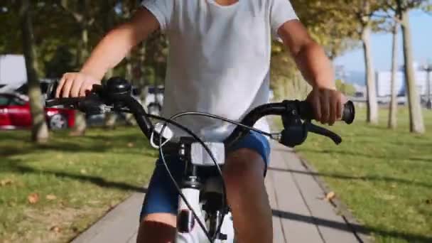 Retrato de una niña está montando una bicicleta y sonriendo, de cerca .. — Vídeo de stock