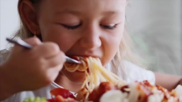 A child girl is eating spaghetti close-up — Stock Video