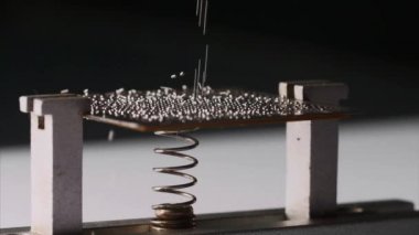 Küçük gümüş metal toplar çip, yan görünüm, yakın çekim düşüyor.
