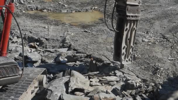 Un martillo de piedra de roca hidráulica excavadora de arrastre es romper el suelo rocoso. Primer plano . — Vídeo de stock