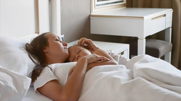 Mutter liegt mit ihrem schlafenden Kind zu Hause im Bett. — Stockfoto