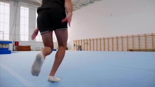 Een sportman doet een Radslag en een dubbele rug Flip en landt, Steadicam. — Stockvideo