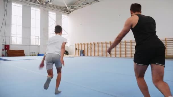 Dwa sportowca robi Cartwheel i podwójne plecy Flip, Steadicam, Slow Motion. — Wideo stockowe