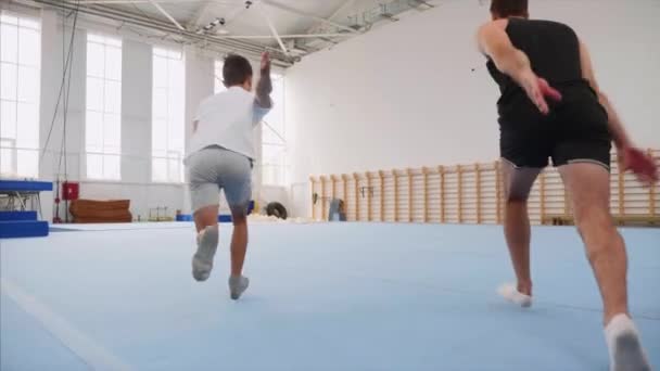 Cartwheel en Tripple Backflip zijn gemaakt door man en jongen, Steadicam, Slow Motion. — Stockvideo