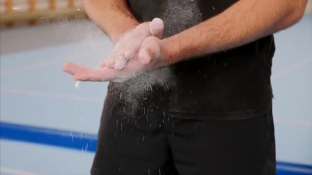 Un deportista está limpiando las manos con magnesia deportiva, primer plano de las armas, cámara lenta . — Vídeos de Stock
