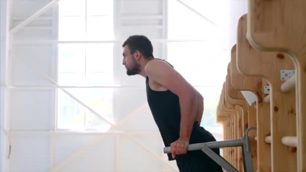 Male athlete making chest dips at the sport center, half body shot, side view. — Stock Video