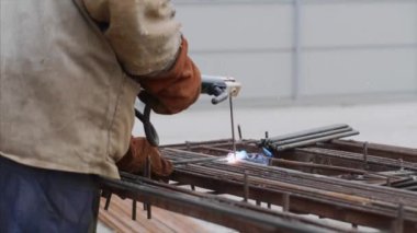Bir işçi içi boş elektrot ile demir kaynak olduğunu. İşlemin yan görünümü.