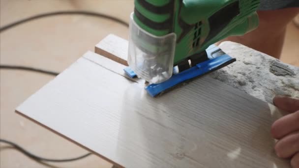 Una vista ravvicinata di tagliare un foro su un pezzo di laminato con puzzle elettrico . — Video Stock