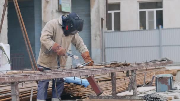 Soldador no local de construção é tubo de soldagem com eletrodo no capacete . — Vídeo de Stock