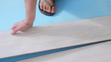 Bir işçi birlikte odada laminat paneller koyarak, döşeme süreci.