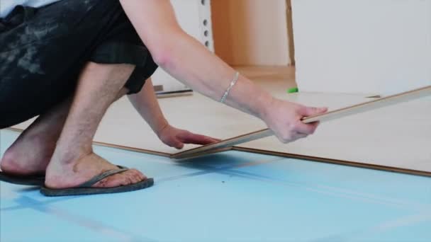 Un trabajador está poniendo paneles laminados juntos en la habitación, el proceso de suelo . — Vídeo de stock