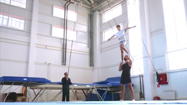 En långsam rörelse av en ung atlet gör en luft tillbaka flip på säkerhet sling — Stockvideo
