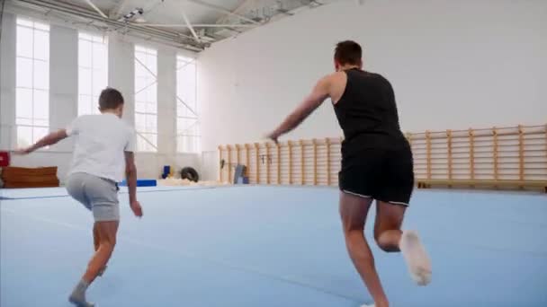 Cartwheel en tripple back flip zijn gemaakt door man en jongen, steadicam. — Stockvideo