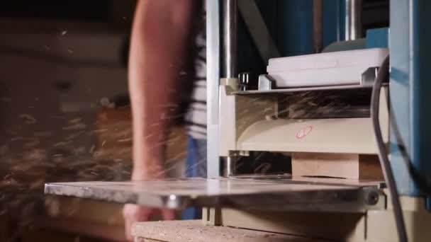 Male carpenter is working with cabinet planer machine at wood workshop — Stock Video