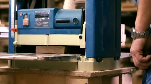 Tischler arbeitet in Holzwerkstatt mit Hobelmaschine — Stockvideo