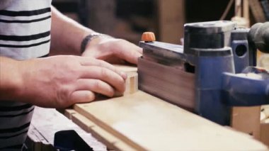 Zanaatkar ahşap atölyesinde öğütme makinesiyle çalışıyor, elleri yakın..