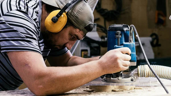 Erkek marangoz, odun kesme işi için değirmen makinesiyle çalışıyor. — Stok fotoğraf