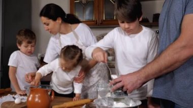 Çocuklar, aile mutfağında hamuru hazırlamaya yardım ediyor.