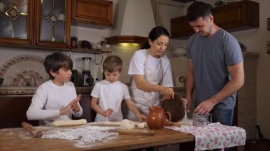 Çocuklar, aile mutfağında hamuru hazırlamaya yardım ediyor.