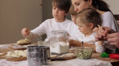Ailesi olan çocuklar ev mutfağında hamur tatlısı hazırlıyorlar.
