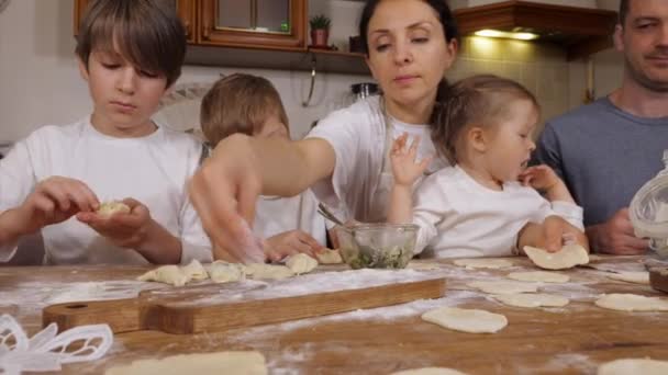 Kinderen met ouders is het bereiden van dumplings in de huishoudelijke keuken — Stockvideo