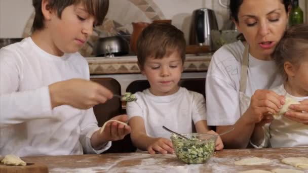 Kinderen met ouders is het bereiden van dumplings in de huishoudelijke keuken — Stockvideo