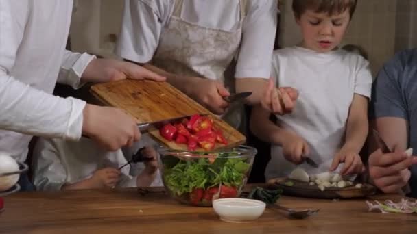 Famille heureuse avec trois enfants cuisine salade à la maison ensemble — Video