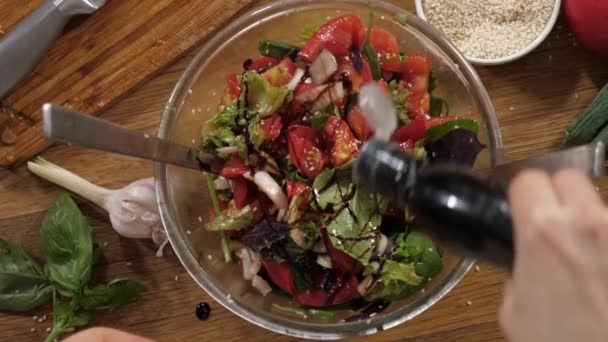 Mulher misturando salada fresca na tigela da classe, close-up . — Vídeo de Stock