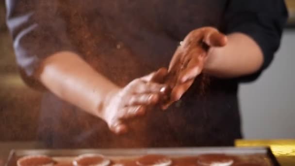 Close-up of chef is clapping his hands filling cocoa over cookies — Stock Video